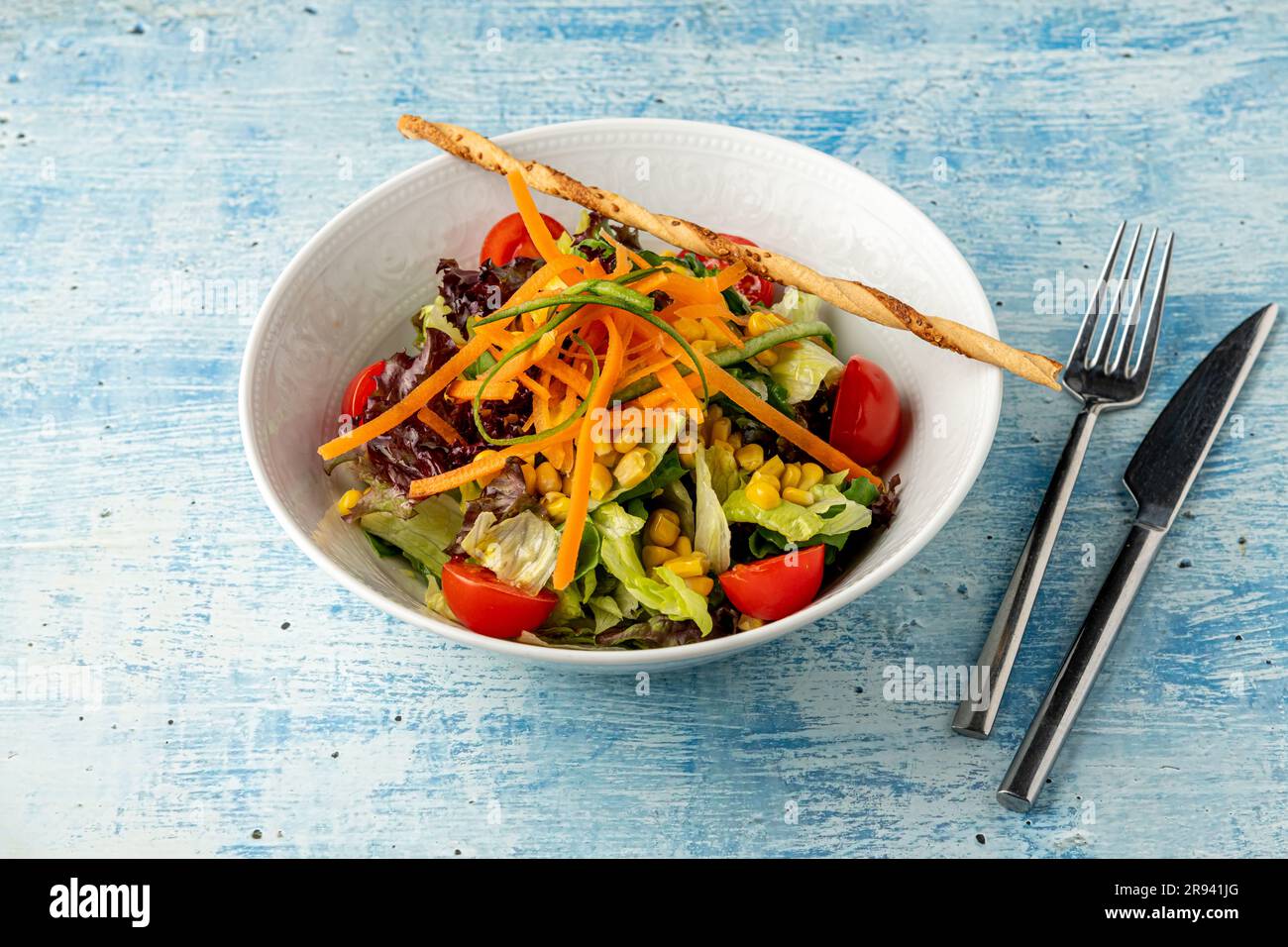 Healthy mixed salad in white bowl on wooden table. Mediterranean salad Stock Photo