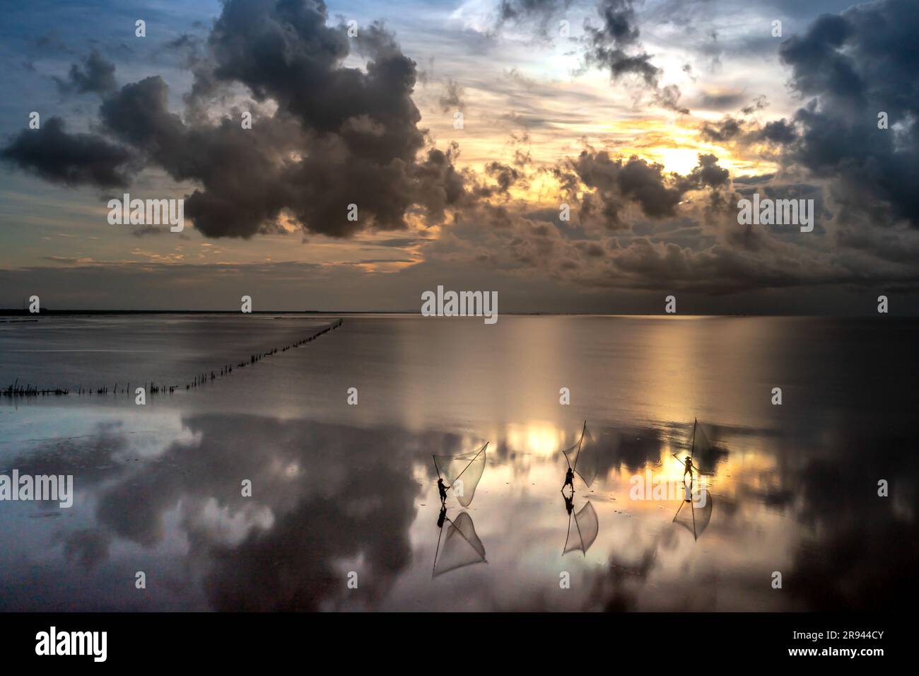 The image of fishermen in the fishing village using homemade tools to clams rake at sea at dawn Stock Photo
