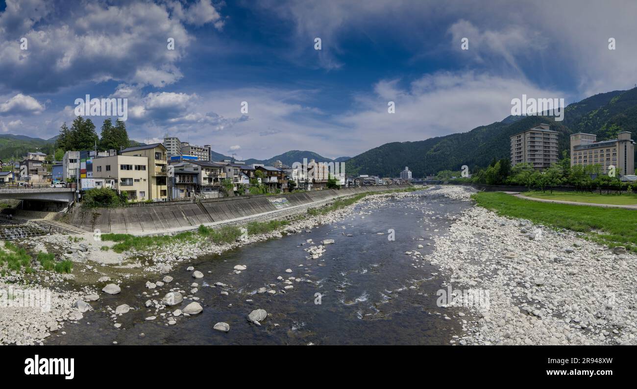 The River Hida flows the through the centre of Gero Onsen, famous for Hot Springs in Gifu Prefecture, Japan. Wide Angle Panorama. Stock Photo