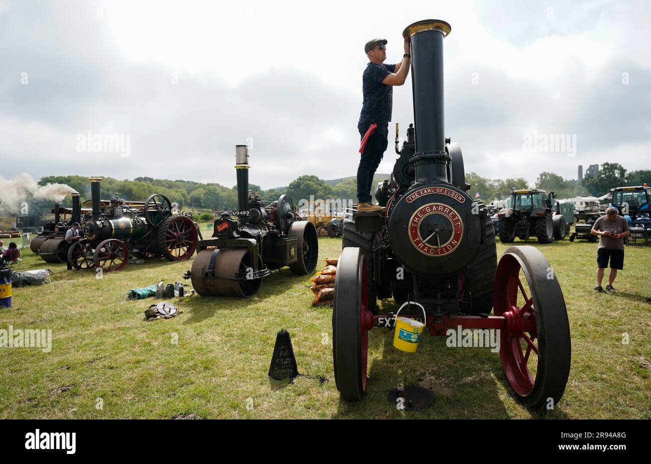 A person cleans the funnel of the Garrett General Purpose Engine 'The Earl of Eldon', during the Roads to Rail steam rally next to Norden station near the village of Corfe Castle, Dorset. The event features up to 50 traction and miniature engines, steam rollers and showman's engines, as well as fairground rides, trade stalls, food stalls, bar and live music. Picture date: Saturday June 24, 2023. Stock Photo