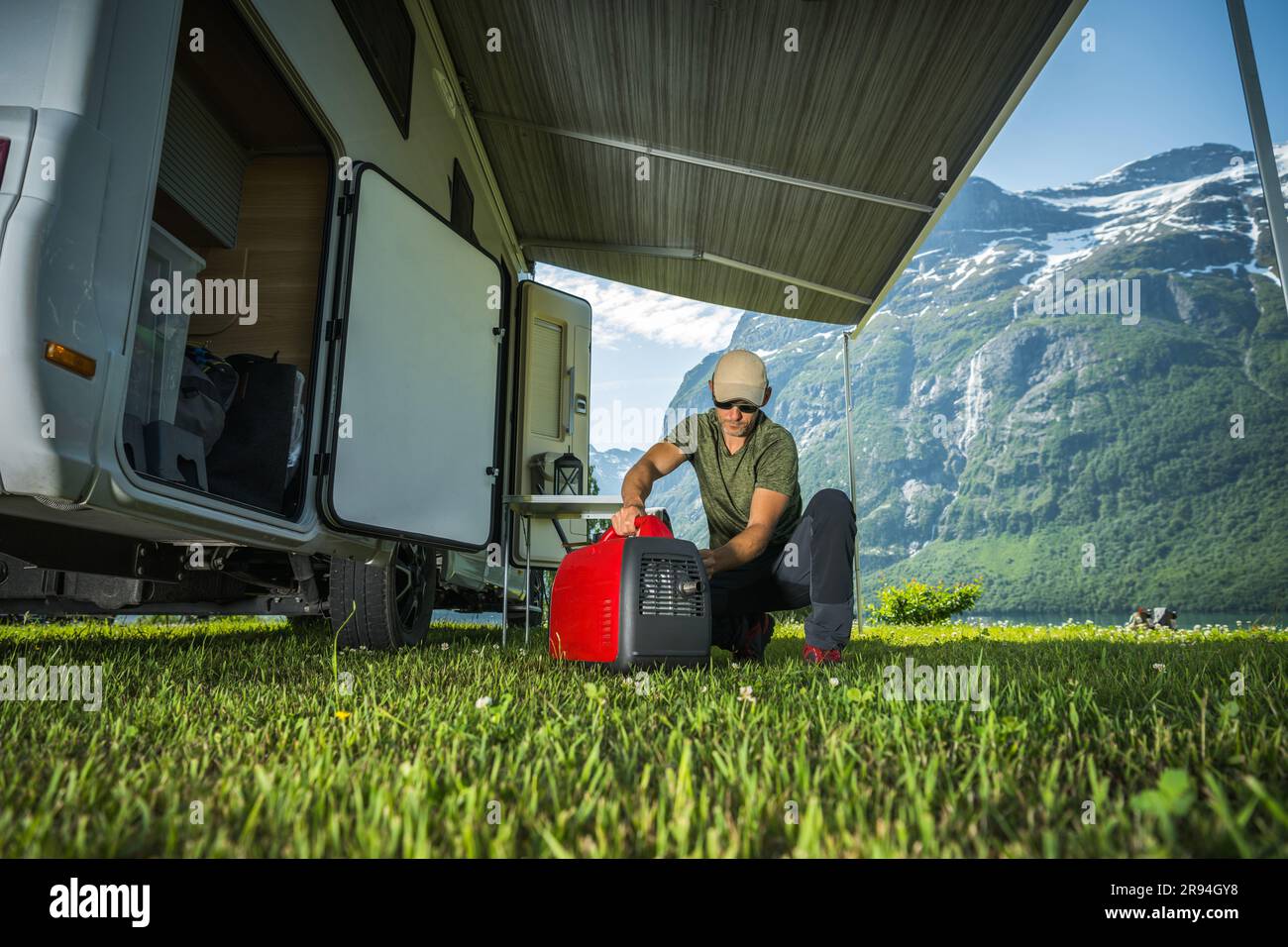 Caucasian Tourist and RV Owner Running Red Portable Inverter Generator To Hook Up the Camper Van