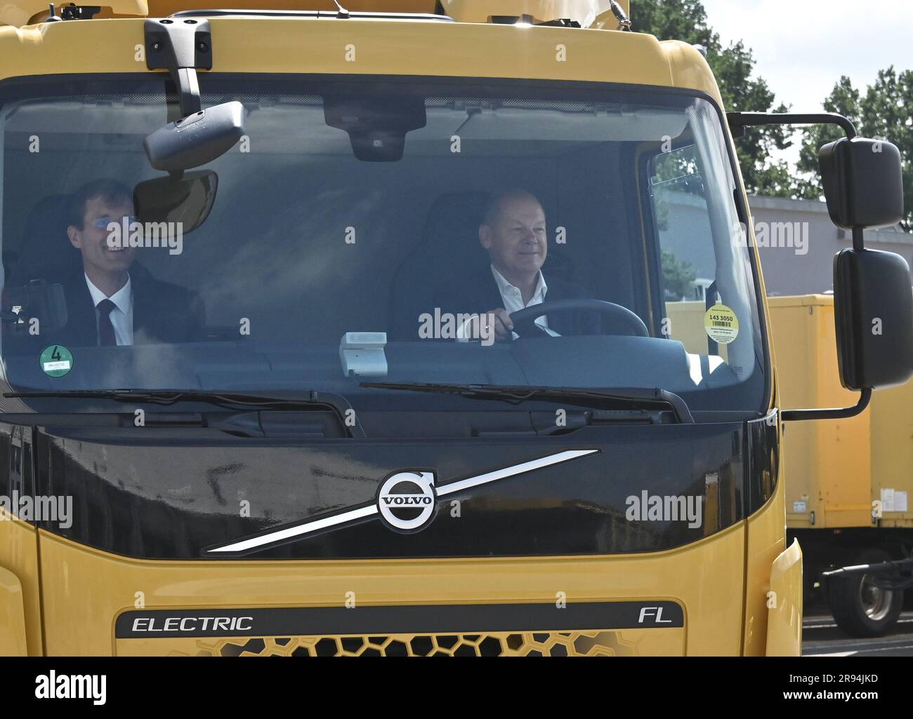 Stahnsdorf, Germany. 24th June, 2023. German Chancellor Olaf Scholz (SPD), drives an electric truck with Tobias Meyer (l) CO Deutsche Post AG at Deutsche Post's mail center in Stahnsdorf. During his visit, he learned about the modern sorting facilities and the possibilities of delivery with electric vehicles. Credit: Bernd Settnik/dpa/Alamy Live News Stock Photo