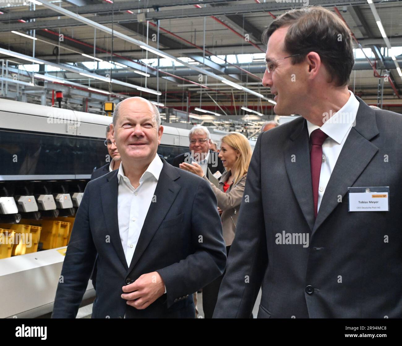 Stahnsdorf, Germany. 24th June, 2023. Tobias Meyer CO Deutsche Post AG (r) gives Chancellor Olaf Scholz (SPD, l), a tour of Deutsche Post's mail center in Stahnsdorf. He familiarized himself with the modern sorting facilities and learned about the possibilities of delivery with electric vehicles. Credit: Bernd Settnik/dpa/Alamy Live News Stock Photo