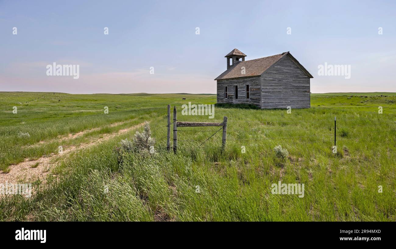Abandoned Cottonwood Lutheran Church and a barbed wire fence near the town of Havre, Montana, USA Stock Photo