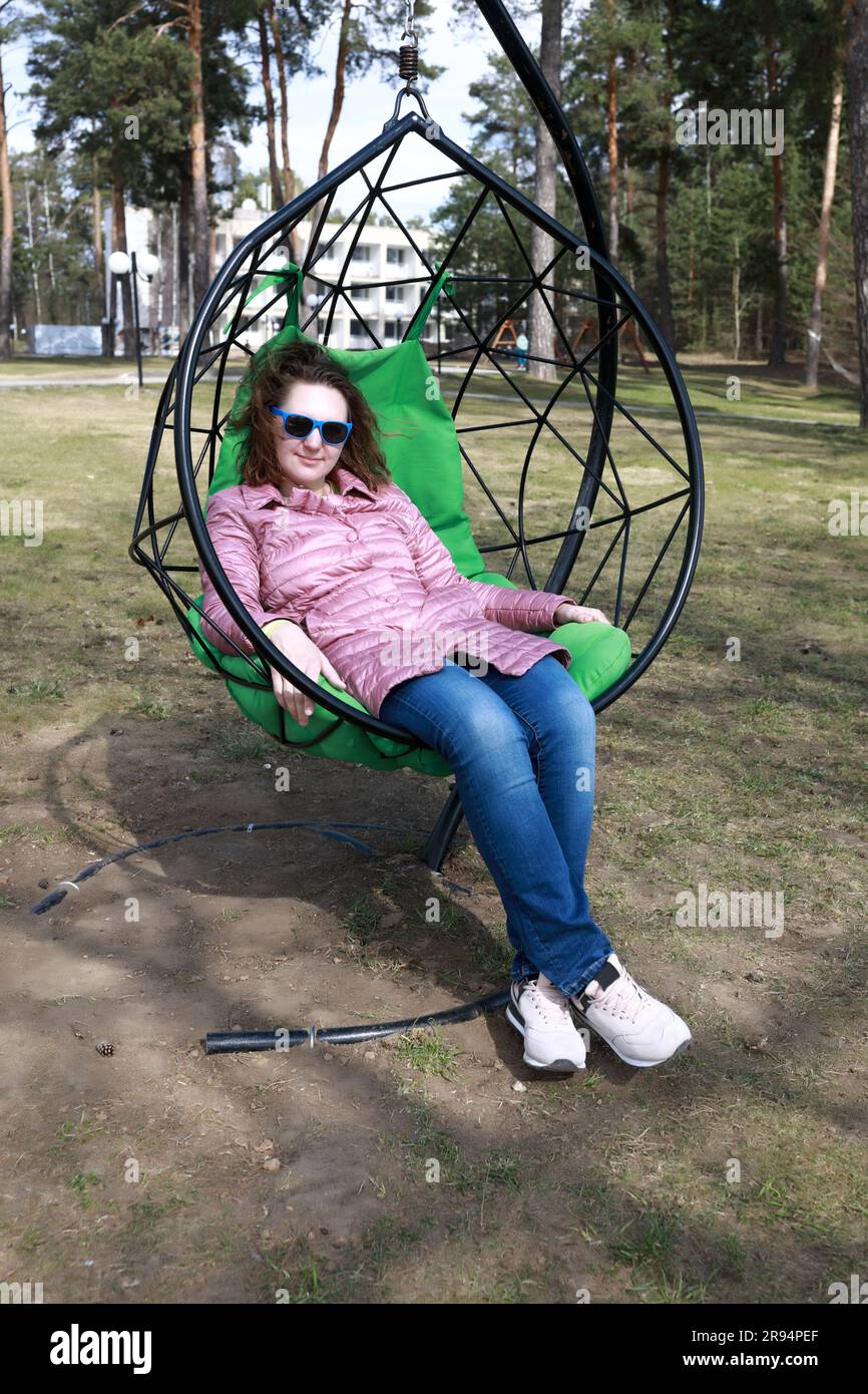 Woman relaxing in hanging chair hi-res stock photography and images - Alamy
