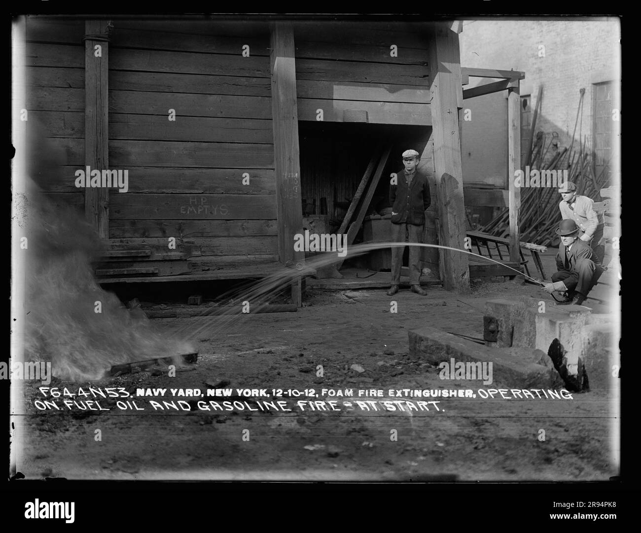 Foam Fire Extinguisher, Operating on Fuel Oil and Gasoline Fire at Start. Glass Plate Negatives of the Construction and Repair of Buildings, Facilities, and Vessels at the New York Navy Yard. Stock Photo