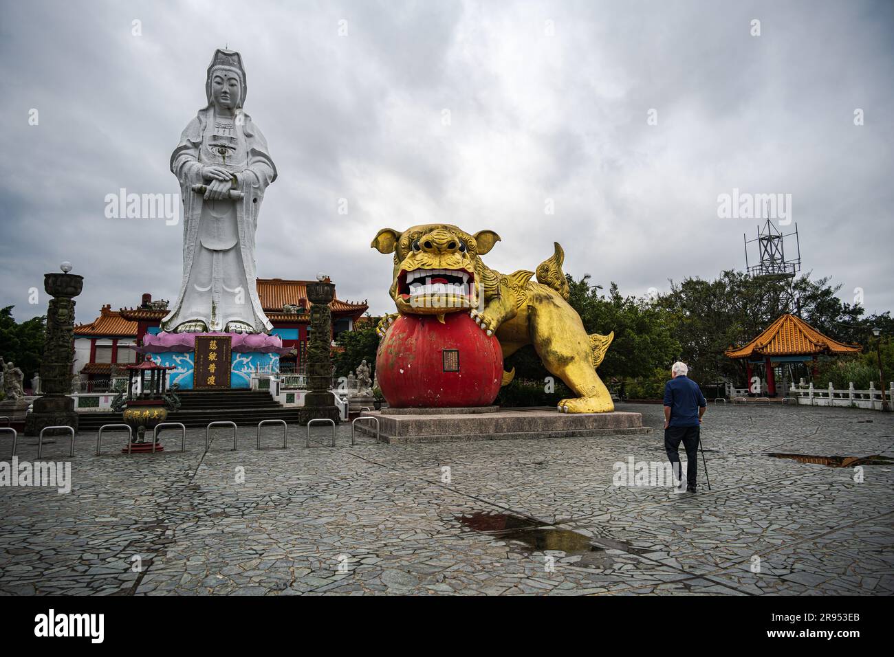 Keelung, Taiwan -- March 14, 2023. A tourist gazes at one of the largest statues in South East Asia of the Goddess Buddha. Stock Photo