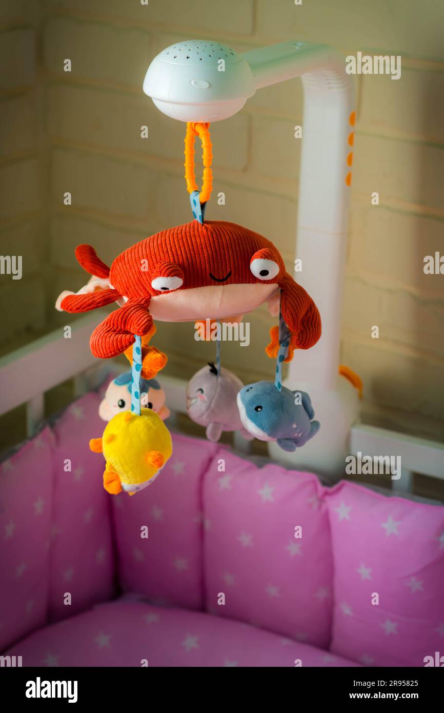 Mobile with soft toys in the crib. Mobile for baby. Children's Toy Red