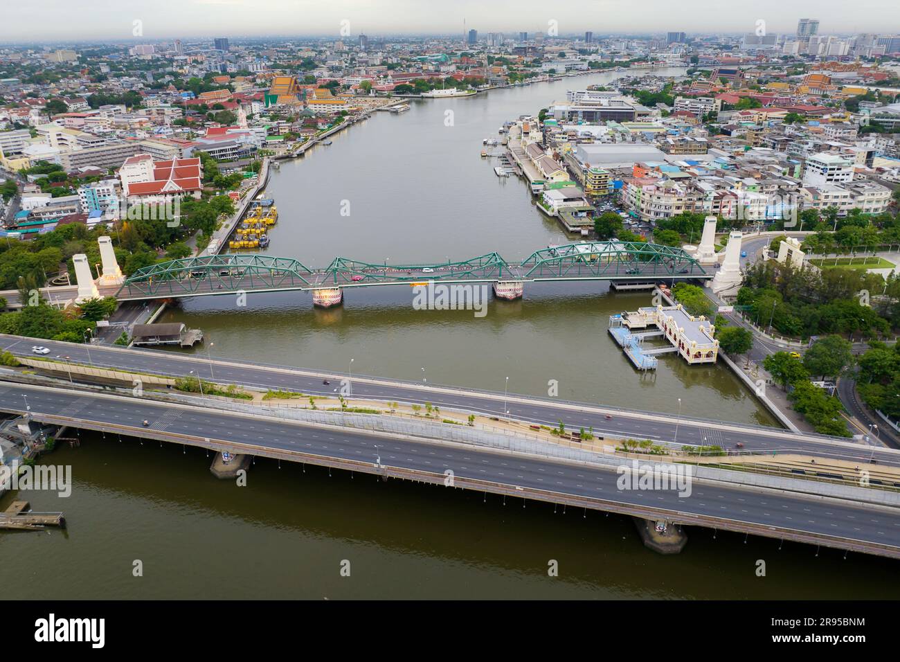 Aerial shots taken from a drone of Phra Pok Klao Bridge and Phra Phuttha Yot Fa Bridge. crossing the Chao Phraya River in the morning with temple and Stock Photo