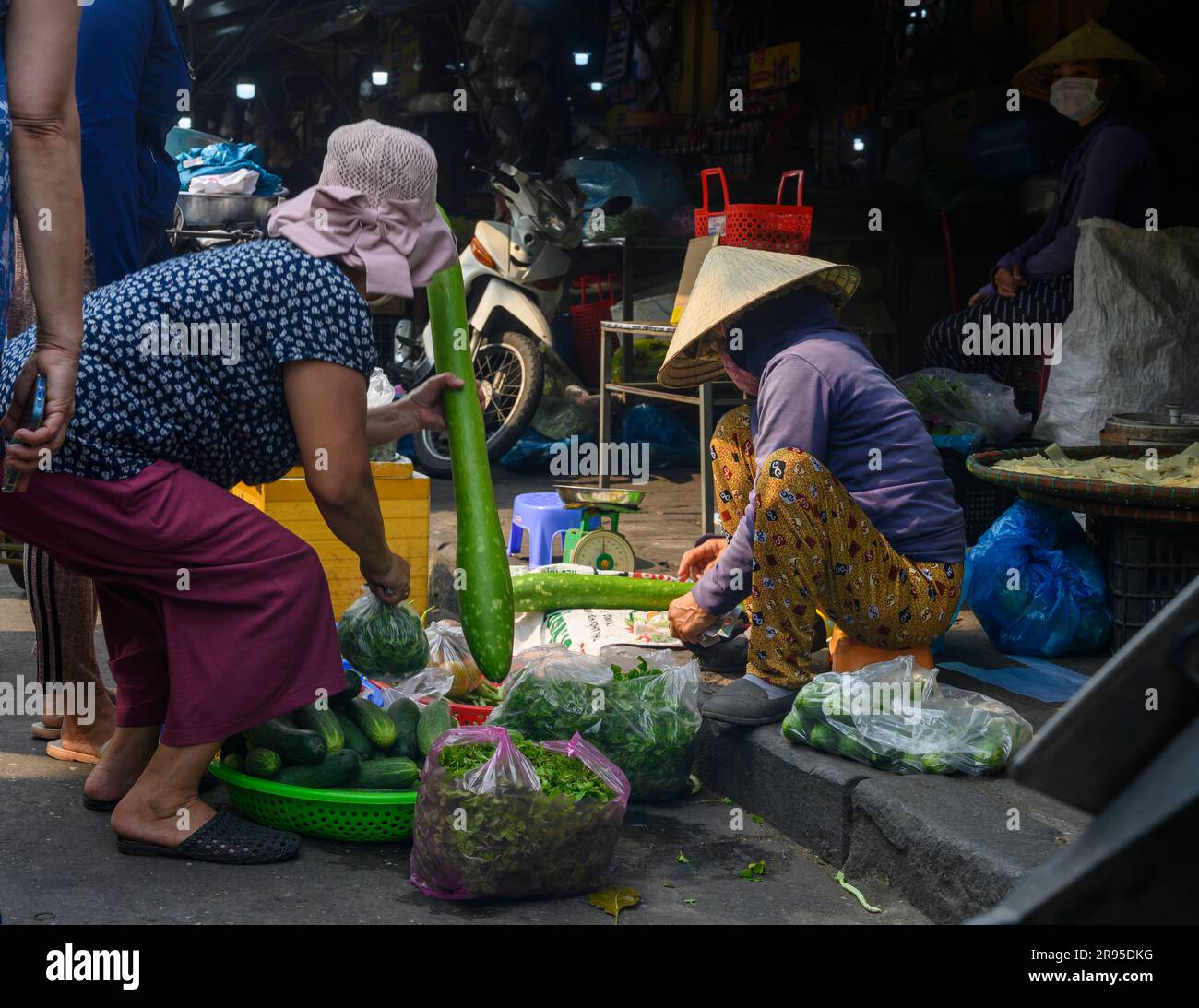 Buying and selling A transaction takes place at a makeshift vegetable stall in Hoi An Market in