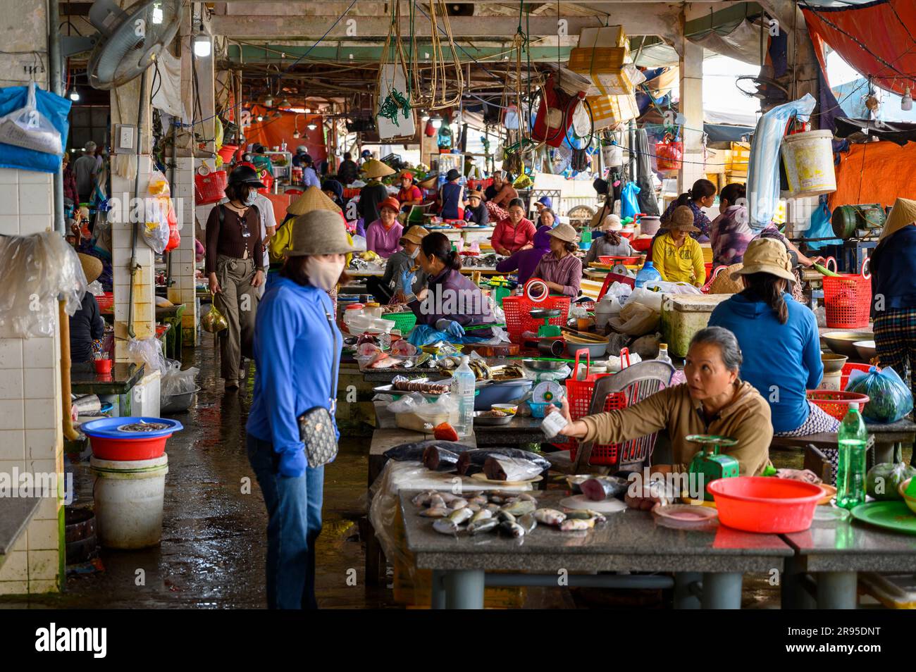 A bustling scene of local buyers and sellers at the fish market in Hoi ...