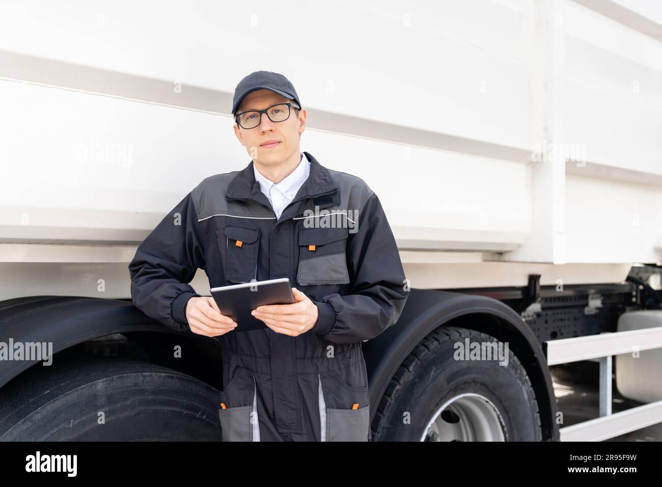 Manager with a digital tablet next to garbage truck Stock Photo