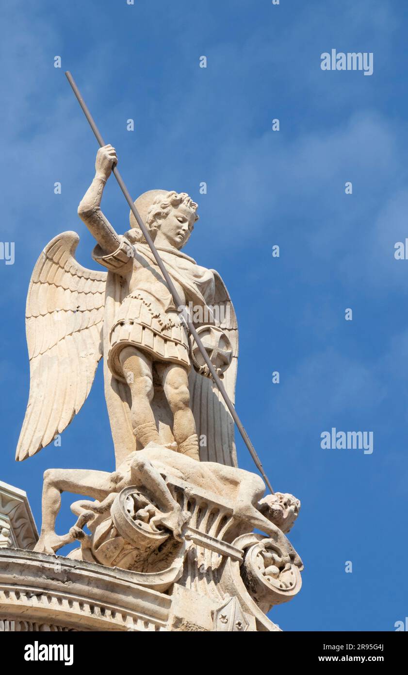 Sibenik, Croatia - May 31, 2023: Stone statue of St Michael killing the Satan , on the top of St Jacobs cathedral in Sibenik, Croatia Stock Photo
