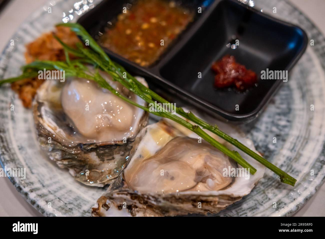 Oyster on served on plate with sauce. Ready to eat Stock Photo