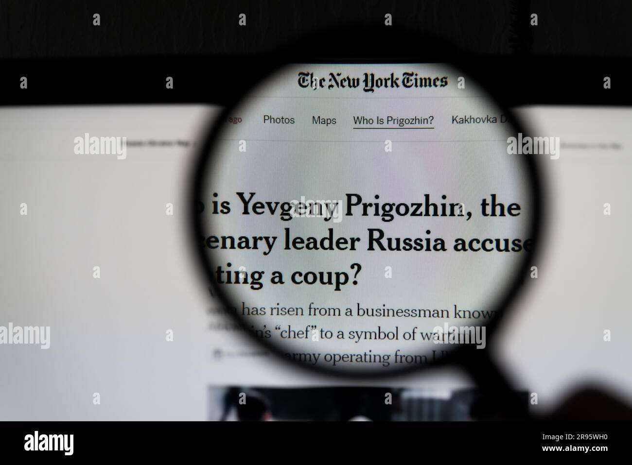 Kyiv, Ukraine - 24 June 2023: The New York Times page on a monitor screen through a magnifying glass with the article Who is Yevgeny Prigozhin, the me Stock Photo