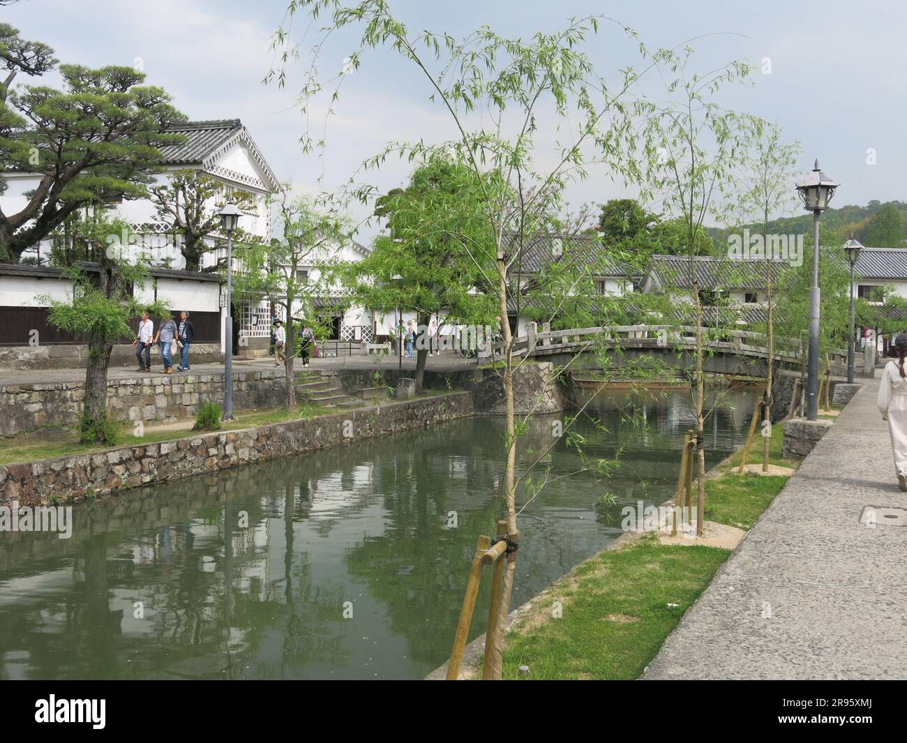 Kurashiki, tourist destination in Okayama: white-walled buildings & willow trees line the banks of the canal that is crossed by pretty arched bridges. Stock Photo