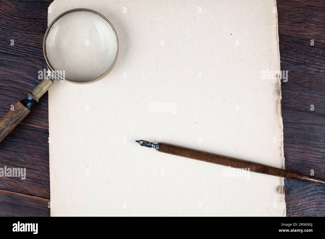 Antique vintage magnifying glass with old ink feather pen on paper ...
