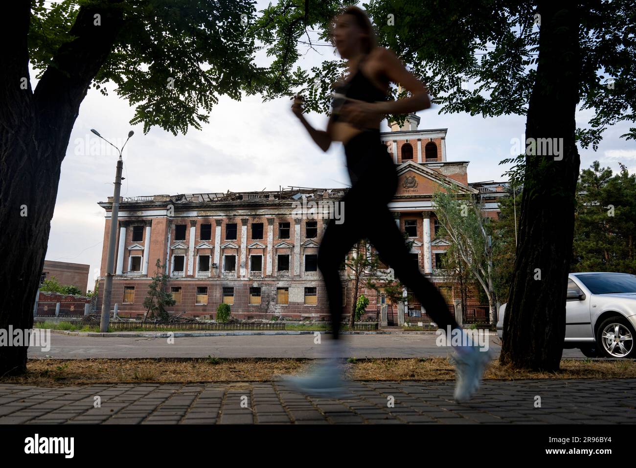 Mykolajiv, Ukraine. 24th June, 2023. Woman is running at the street front of destroyed building in Mykolaiv, Ukraine, June 24, 2023. Credit: Ondrej Deml/CTK Photo/Alamy Live News Stock Photo