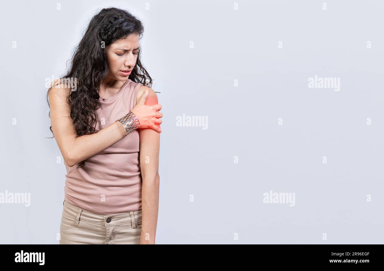 Sore young woman with arm pain isolated. Woman suffering with arm pain