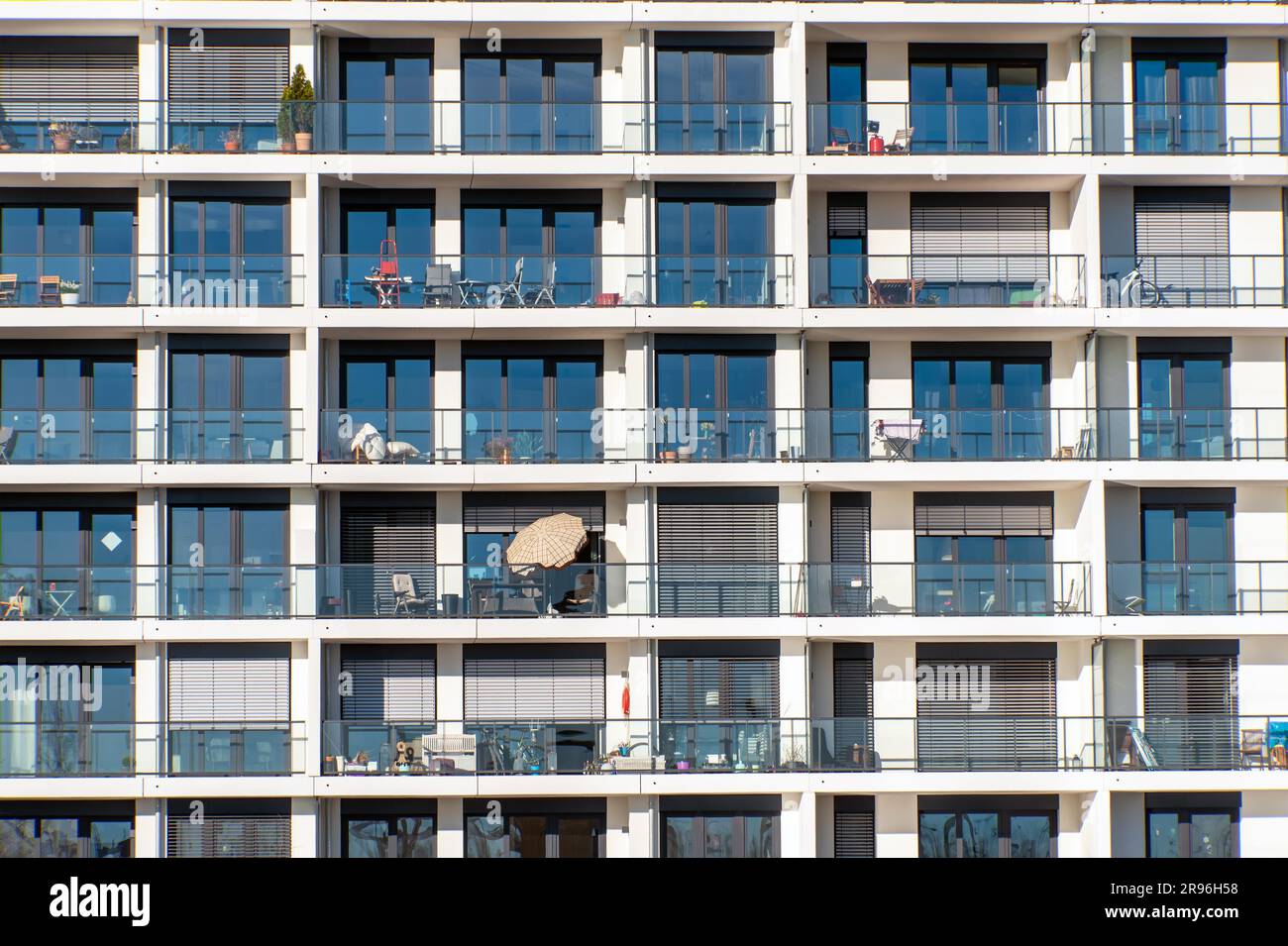 Glass facade of a modern apartment building with many balconies seen in ...