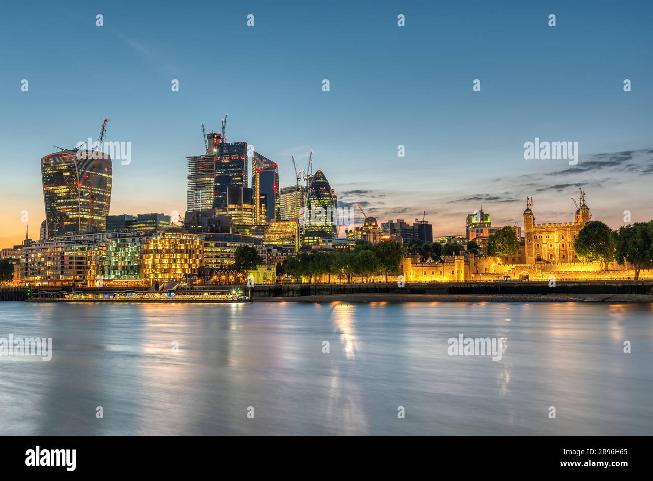 The skyscrapers of the City and the Tower of London after sunset Stock Photo