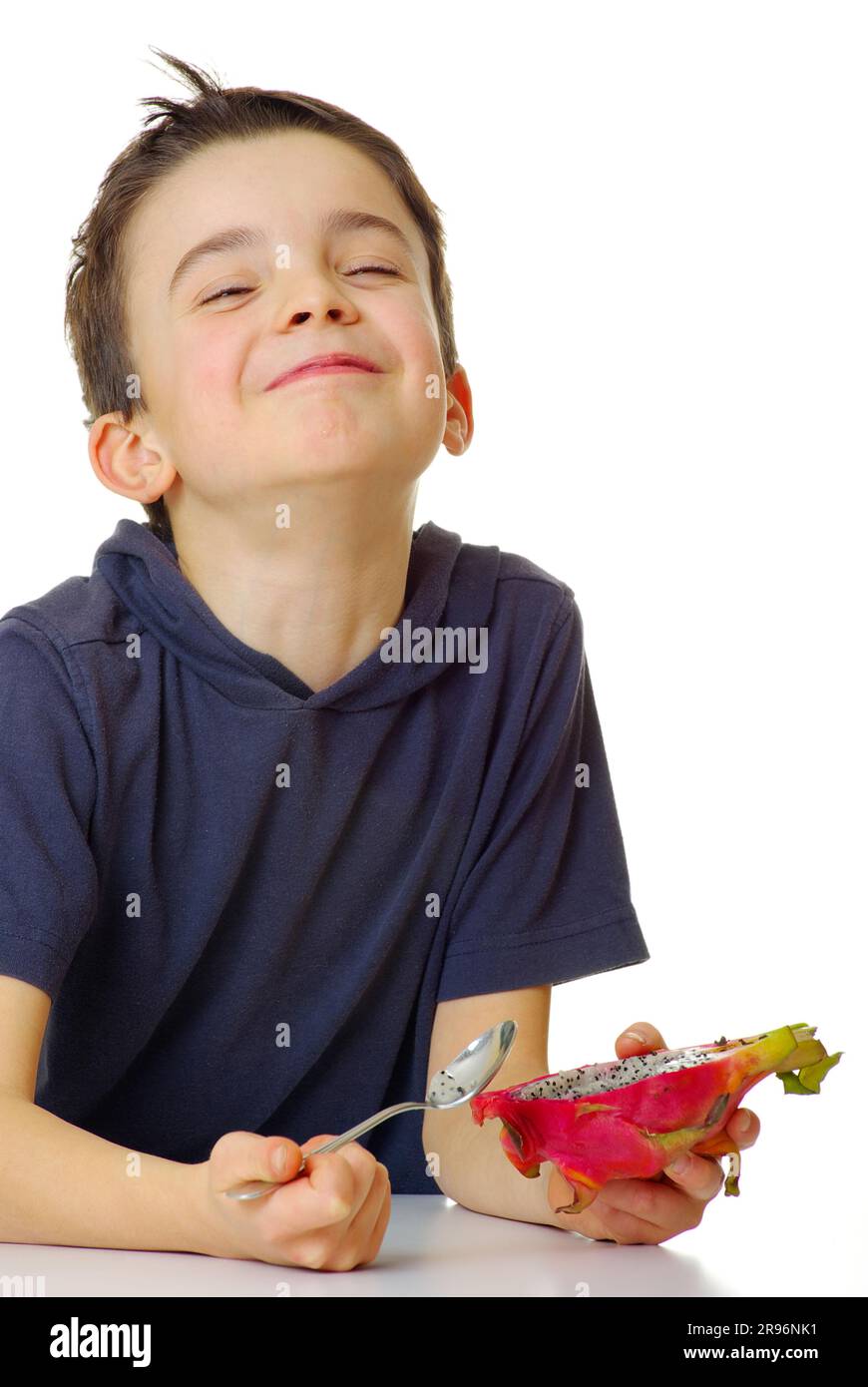 Boy eats pitahaya with triangular hylocereus (Hylocereus triangularis), cactus fruit, dragon fruit, spoon, pitaya Stock Photo