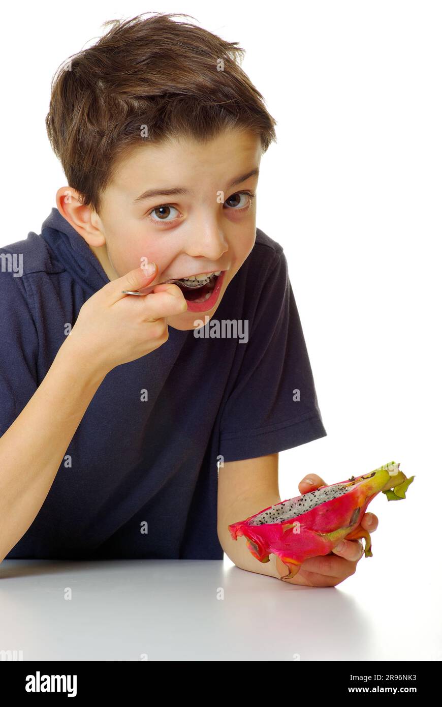 Boy eats pitahaya with triangular hylocereus (Hylocereus triangularis), cactus fruit, dragon fruit, spoon, pitaya Stock Photo