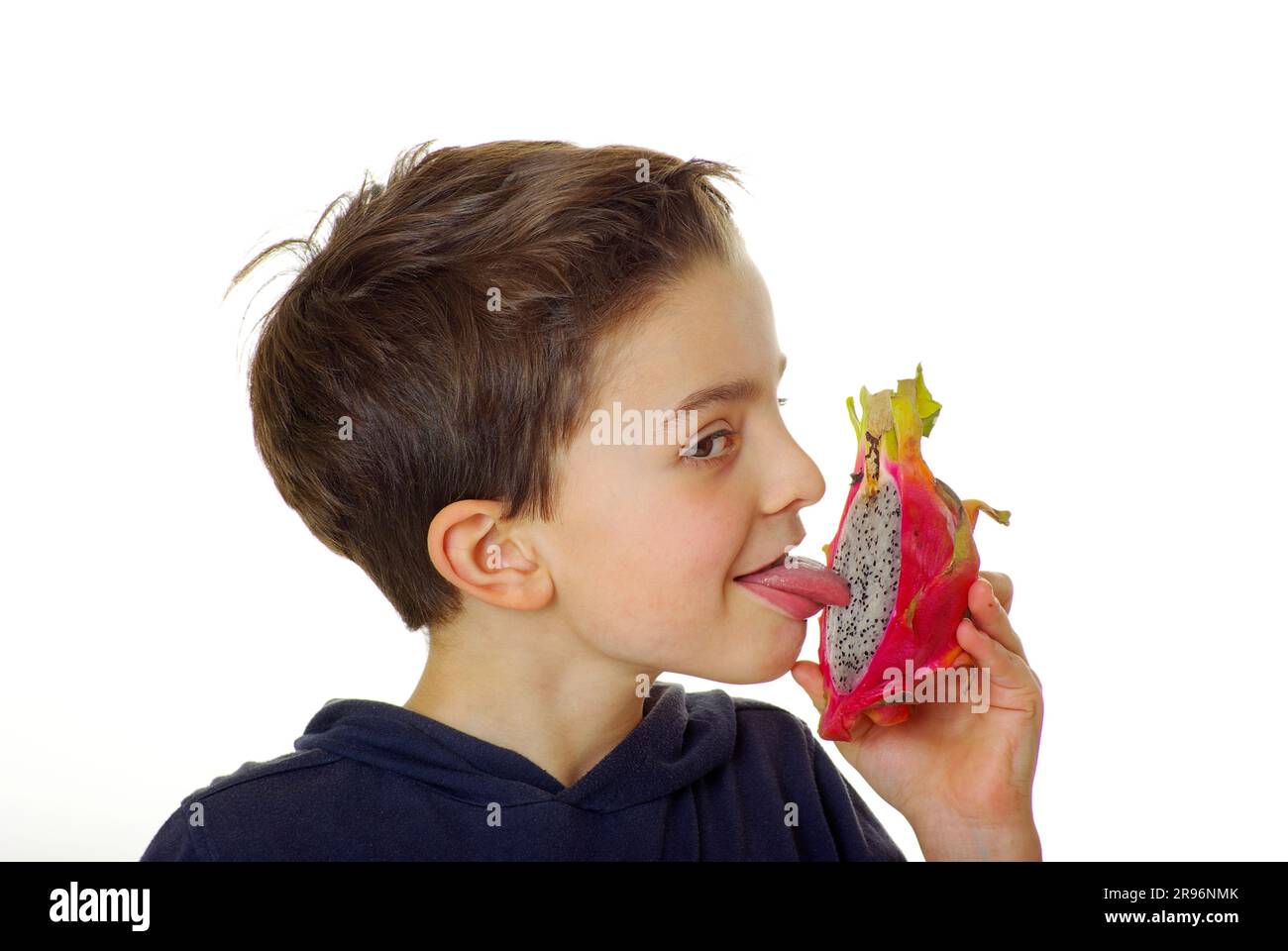 Boy licking triangular hylocereus (Hylocereus triangularis), cactus fruit, dragon fruit, pitaya Stock Photo