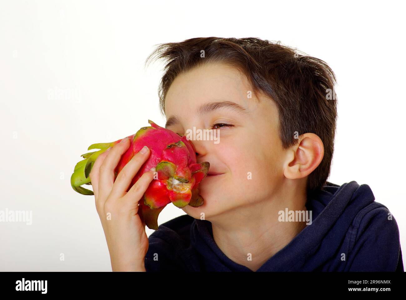 Boy smells triangular hylocereus (Hylocereus triangularis), cactus fruit, dragon fruit, smell, pitaya Stock Photo