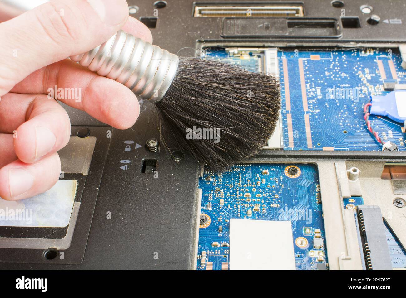 Cleaning the notebook system with a brush during maintenance. Stock Photo