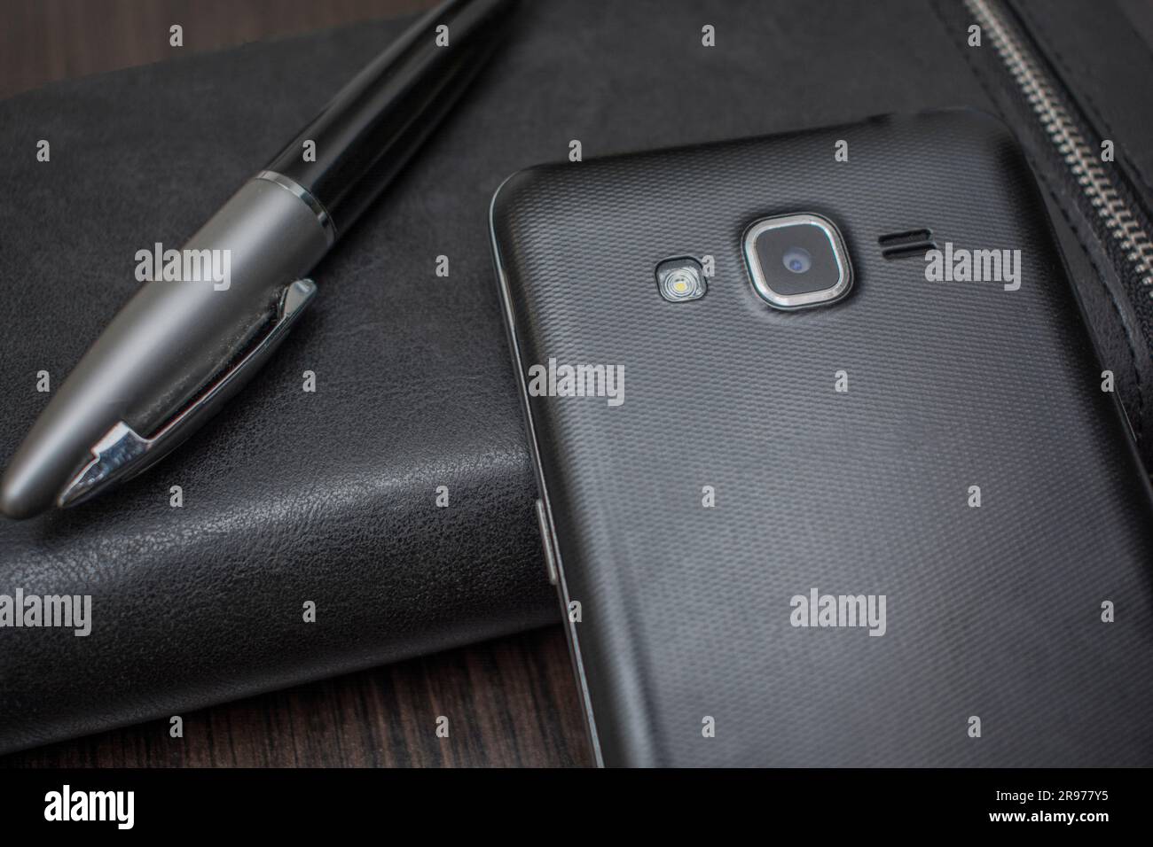 phone with a pen and purse lie on a wooden table background Stock Photo