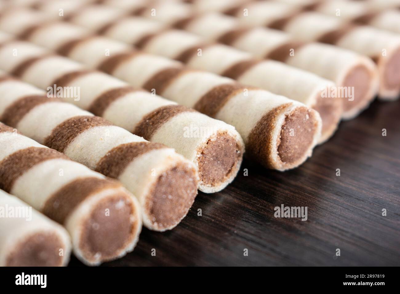 Striped waffle rolls filled with chocolate closeup background Stock Photo