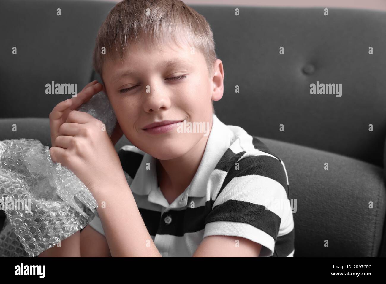 Boy popping bubble wrap at home. Stress relief Stock Photo - Alamy