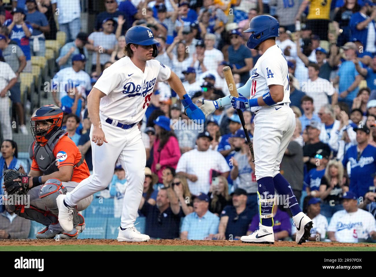 Los Angeles Dodgers' Jonny Deluca, center, is congratulated by Miguel  Rojas, right, after scoring on a balk as Houston Astros catcher Yainer Diaz  kneels at the plate during the eighth inning of