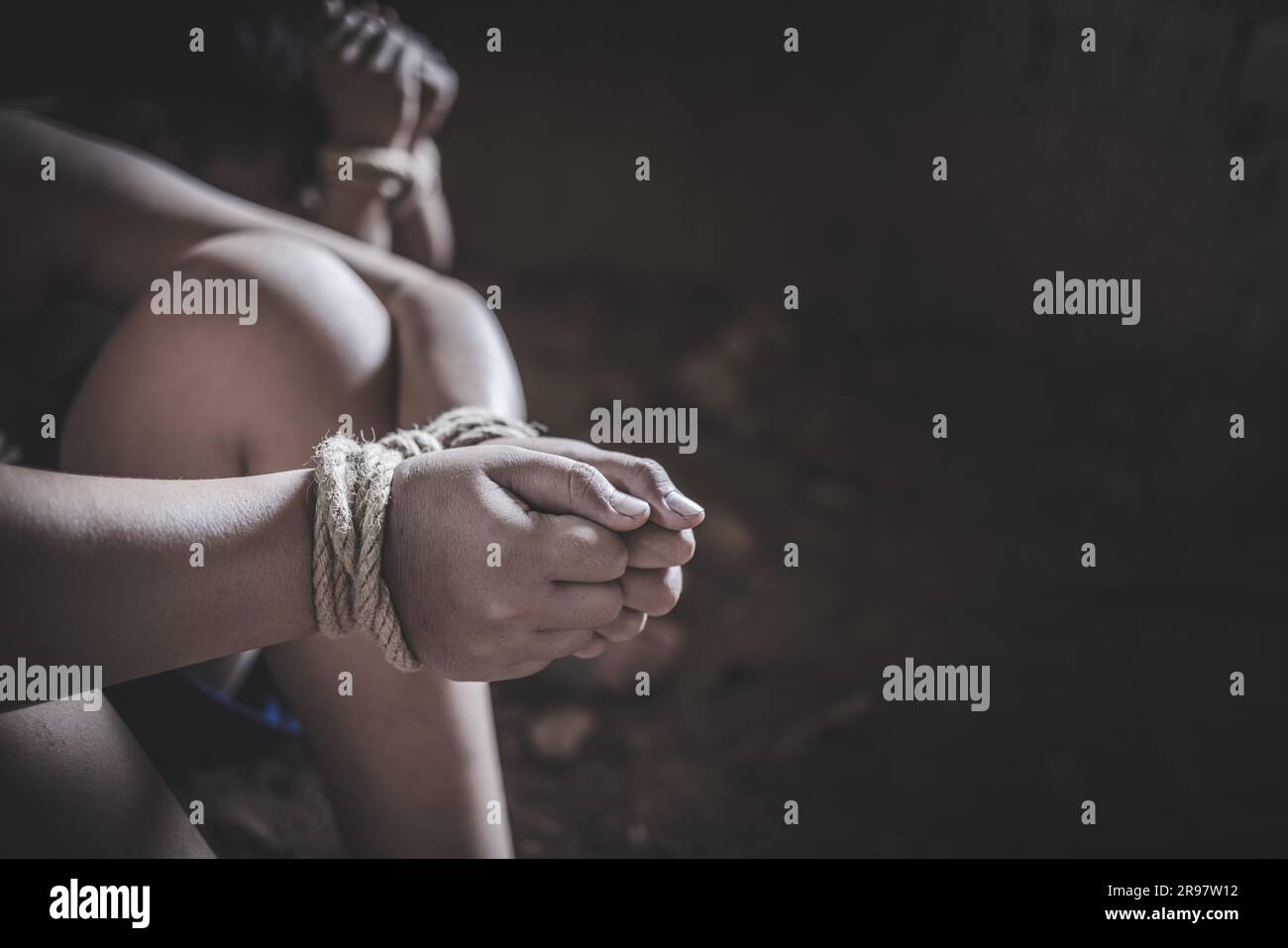 Hands of a missing kidnapped, abused, hostage, victim woman tied up with rope in emotional stress and pain, Human trafficking ,Stop abusing violence. Stock Photo