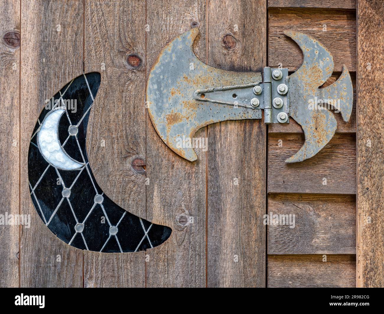 A gothic metal hinge and crescent moon design on an old wooden door ...