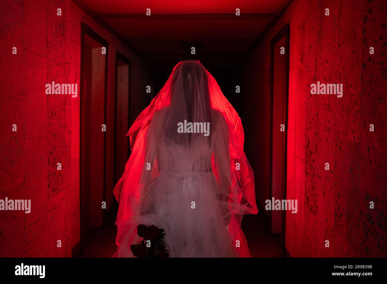 Horror scene of a corpse bride standing in haunted house with red light. Halloween scary celebrating Stock Photo