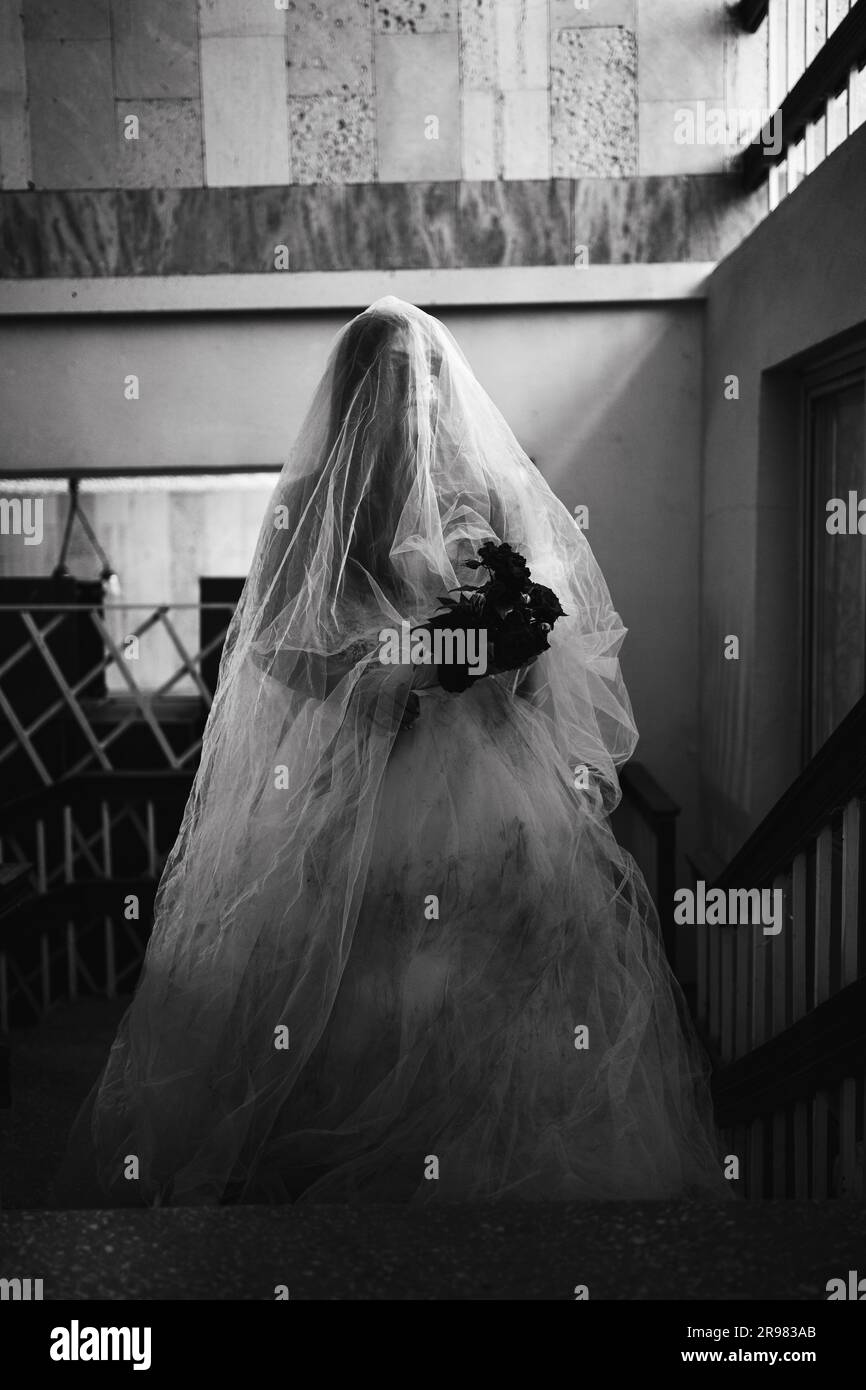Horror scene of a scary woman in white dress in an abandoned building.  Halloween scary concept Stock Photo - Alamy
