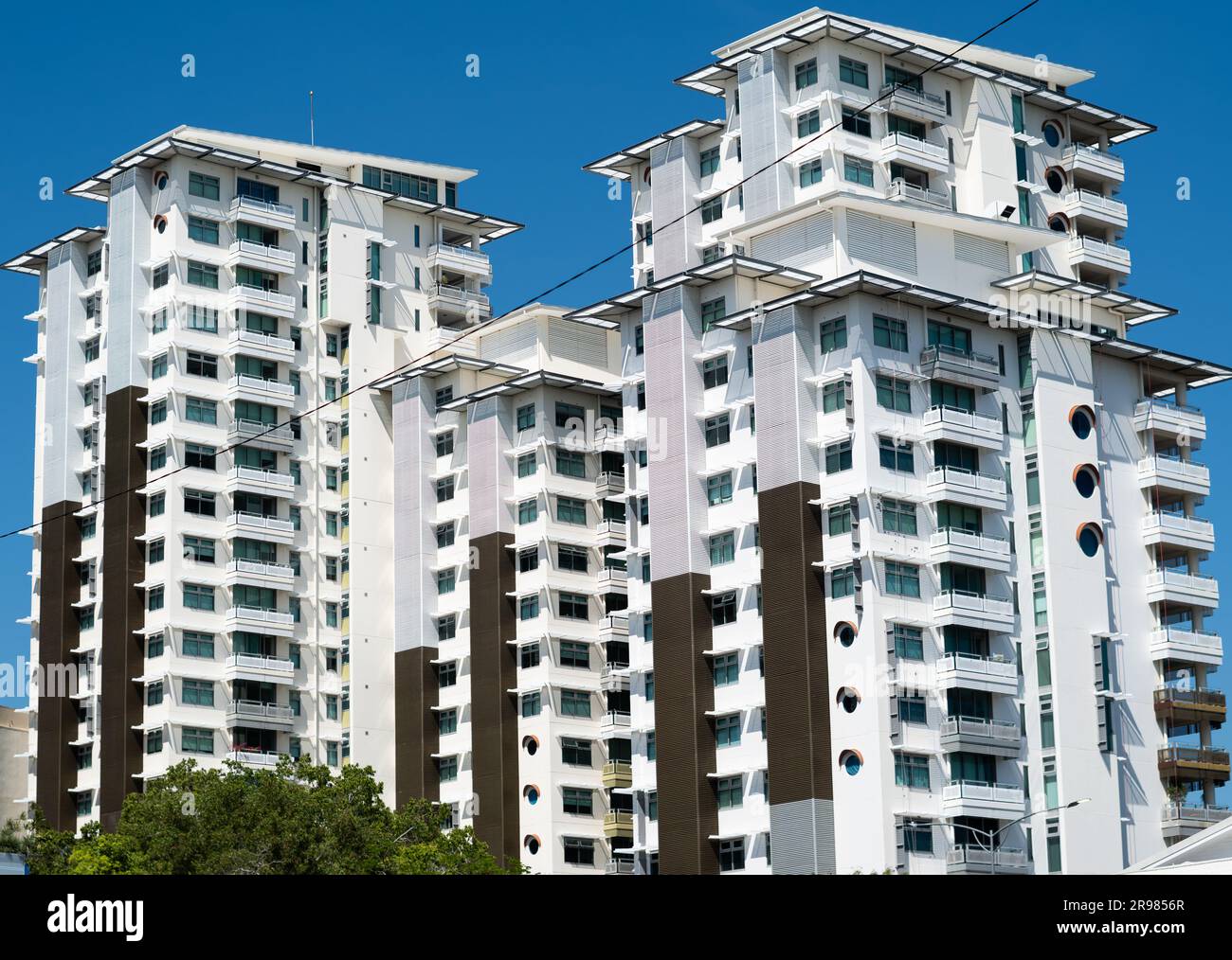 A photograph of a large multi block high-rise apartment complex, located in Darwin, and painted in white with bronze colored trimmings. Stock Photo