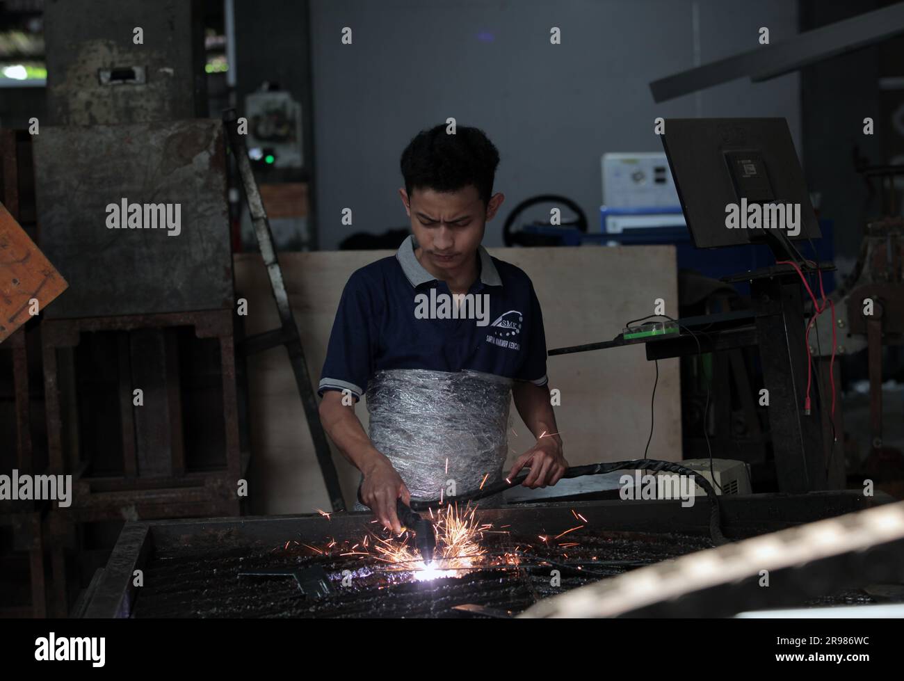 Jakarta, Indonesia June 20, 2023 A worker cuts iron plates with a