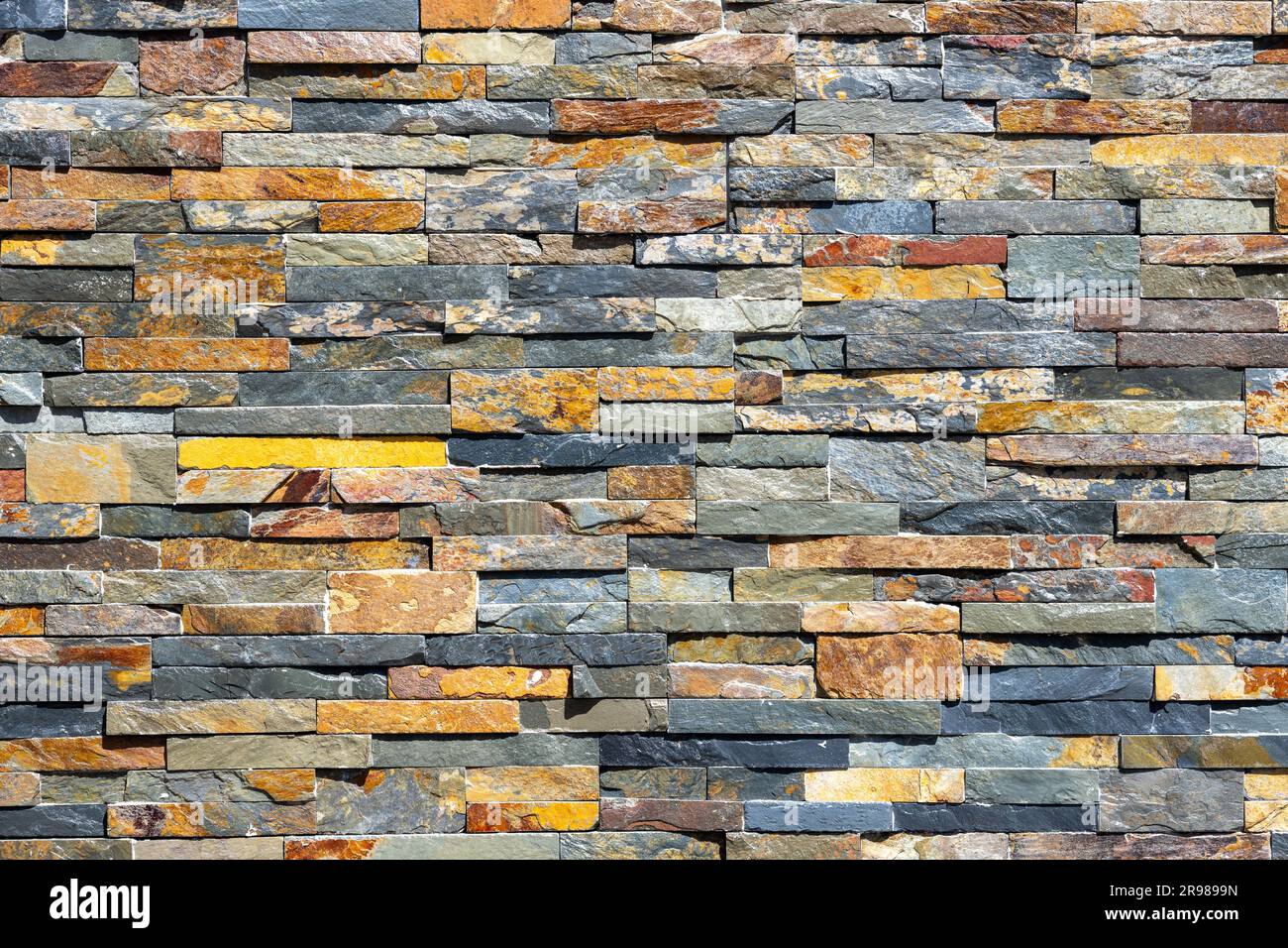 Background from a wall made of small stone tiles Stock Photo