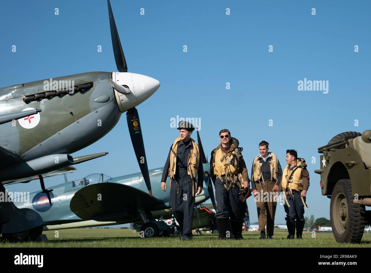 Spirit of Britain living history group stand by a Supermarine Spitfire during the annual Duxford Summer Air Show at IWM Duxford in Cambridgeshire. This year marks the 50th anniversary of the first air show at Duxford. Picture date: Sunday June 25, 2023. Stock Photo