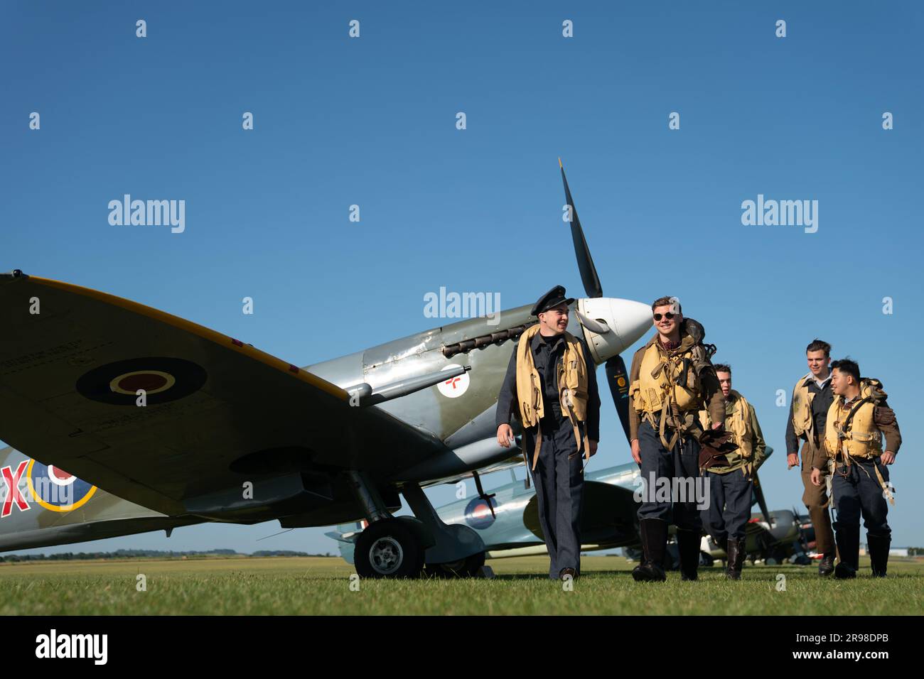 Spirit of Britain living history group stand by a Supermarine Spitfire during the annual Duxford Summer Air Show at IWM Duxford in Cambridgeshire. This year marks the 50th anniversary of the first air show at Duxford. Picture date: Sunday June 25, 2023. Stock Photo