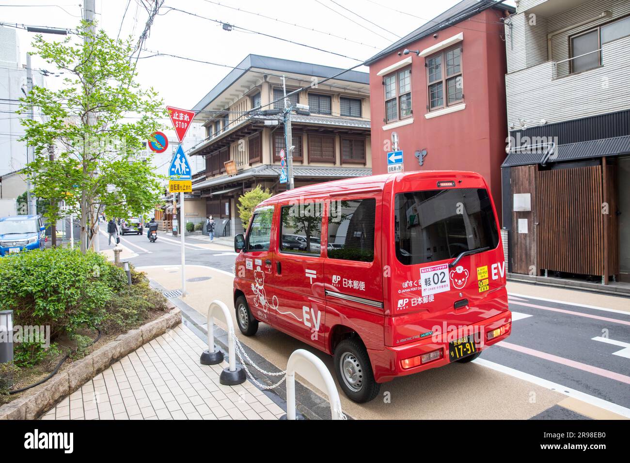 Kyoto japan red postal post mail van electric vehicle in downtown kyoto