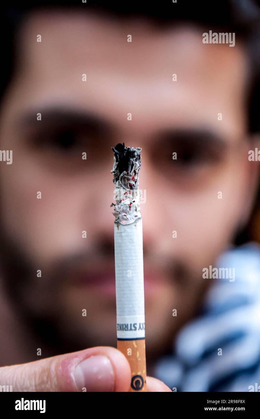 Istanbul, Turkey - June 11, 2021: Young man holding a Lucky Strike cigarette against his face. Stock Photo