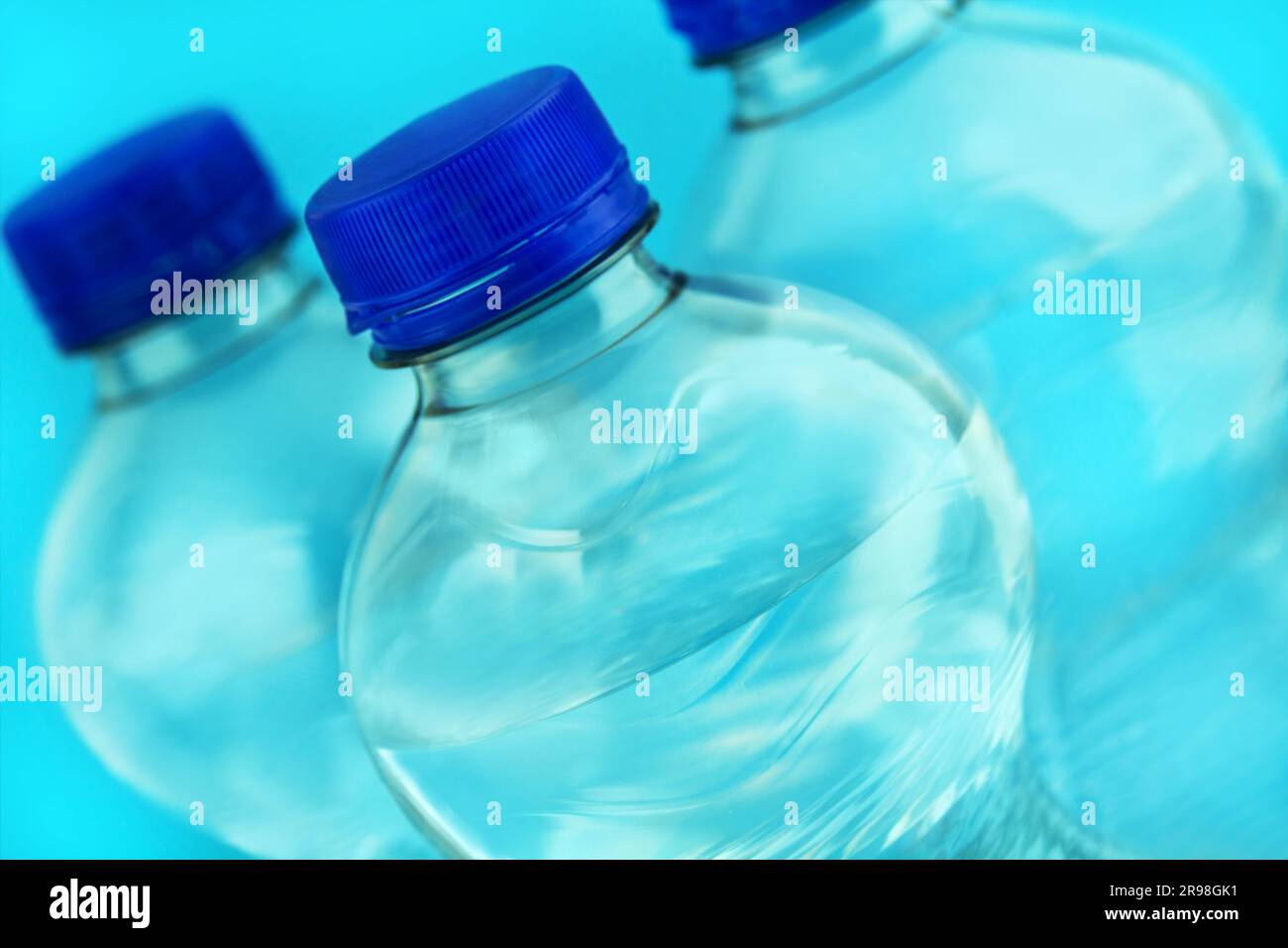 3 Flaschen Mineralwasser in der Nahaufnahme und blauer Hintergrund Stock Photo