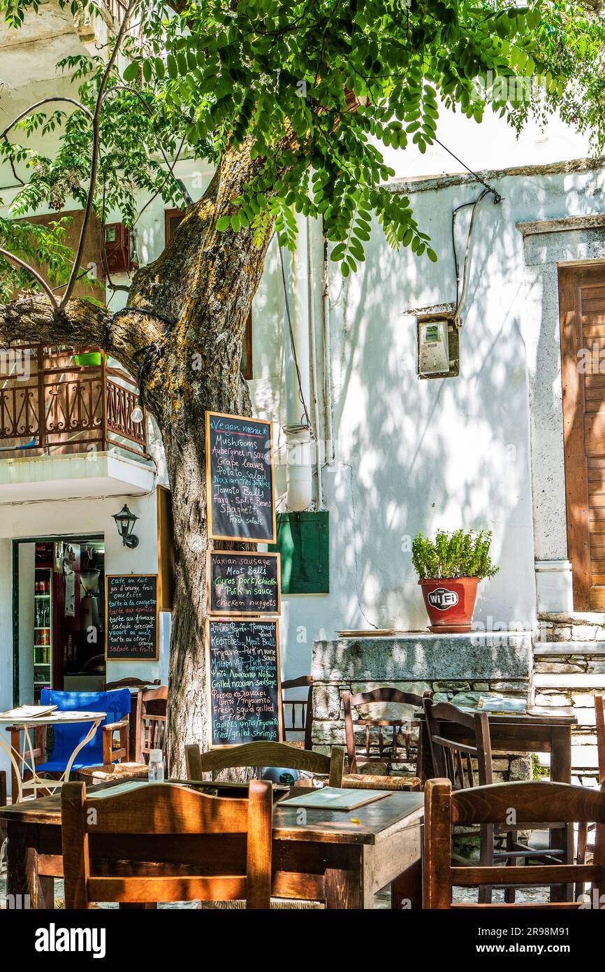 Traditional village cafe with menu outside in Apeiranthos, a mountain village on Naxos, Greece. Greek food. Stock Photo