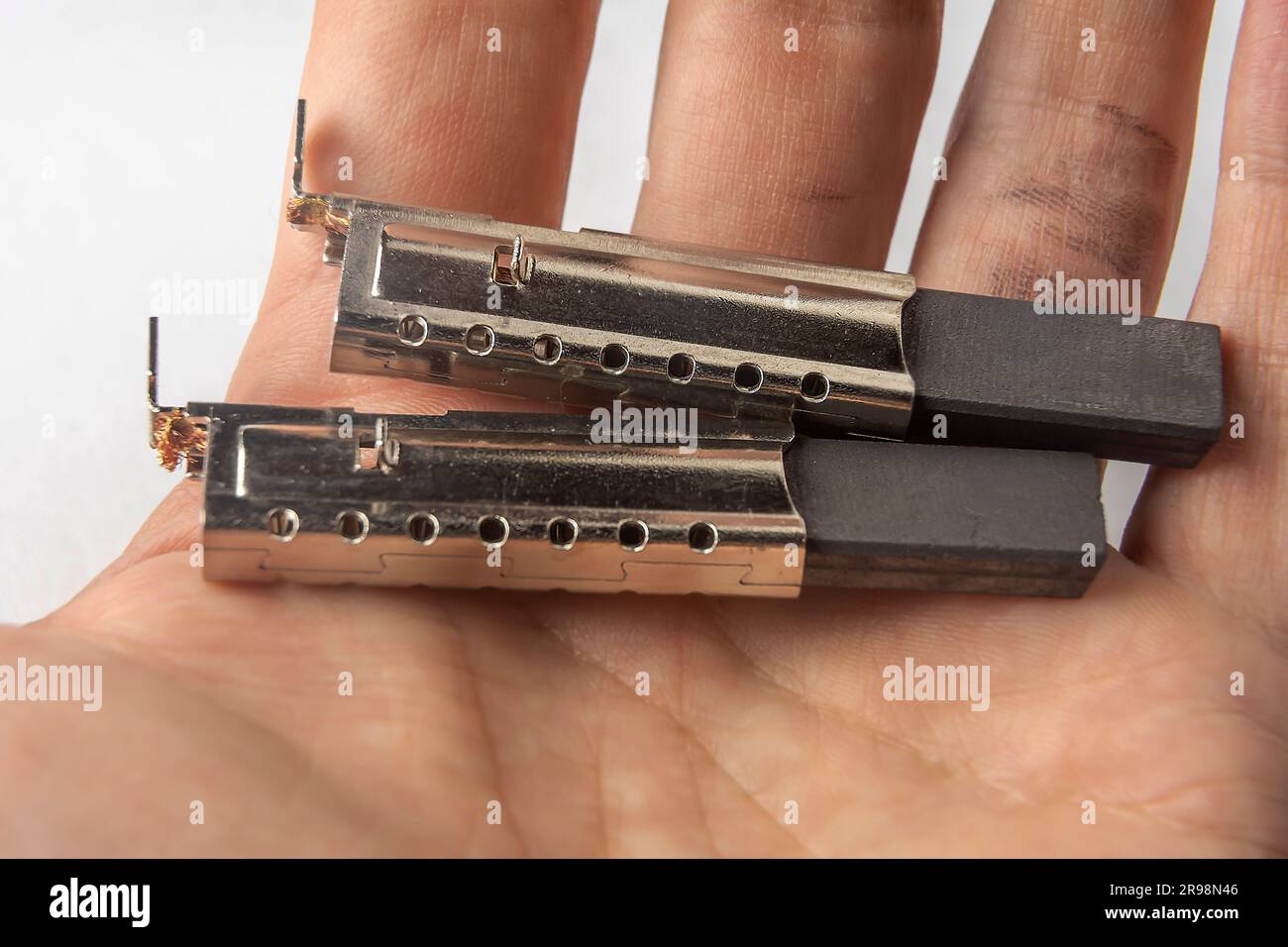 new electric brushes in the hand of a repairman. replacement of