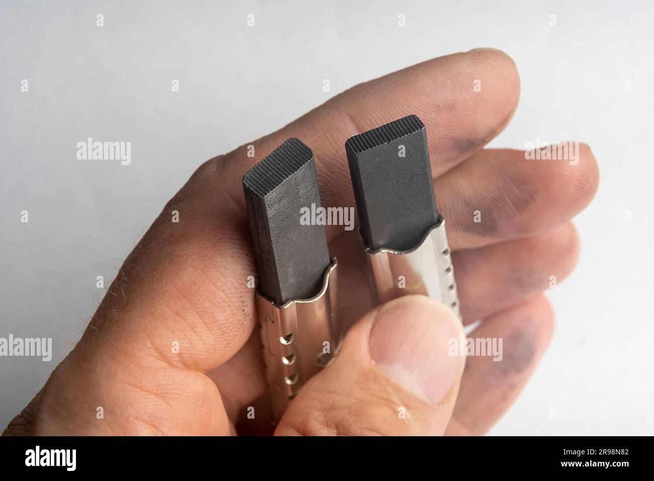 new electric brushes in the hand of a repairman. replacement of