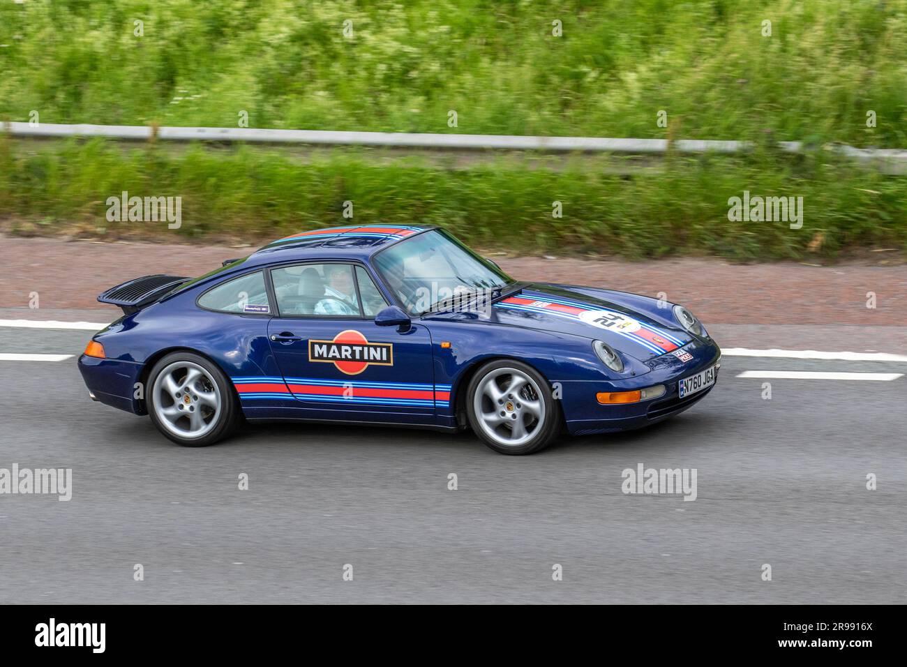 Car No.24 1995 90s nineties Blue Martini Porsche 911 Carrera, Coupe 3600 cc, travelling at speed on the M6 motorway in Greater Manchester, UK Stock Photo